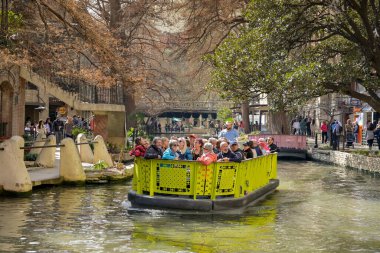 San Antonio, Teksas, ABD - Şubat 2023: Şehir merkezinden geçen nehir teknelerinden birinde ziyaretçiler