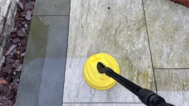 Bahçe bahçesindeki kirli porselen levhaları temizlemek için yüksek basınçlı çamaşır makinesi kullanılıyor. Kimse yok.. 