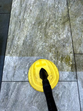 Yüksek basınçlı jet yıkama ekipmanları bahçe avlusunda porselen fayansların temizlenmesinde kullanılırken, temizlikten önce ve sonra parçaların kontrastı kullanılıyor. Kimse yok..