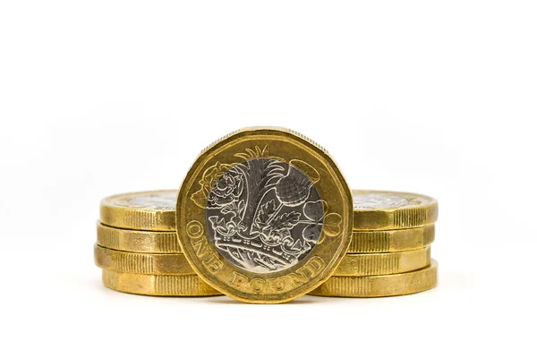 イギリスの1ポンド硬貨はその端に立っており 他の硬貨は白地を背景に孤立していた スペースのコピー — ストック写真