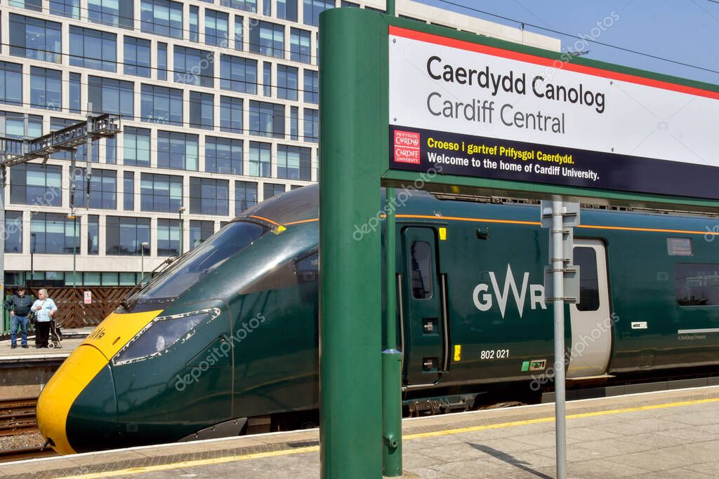 Cardiff, Wales - June 2023: High speed train operated by Great Western Railway alongside a name sign at Cardiff Central railway station