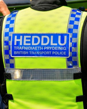 Cardiff, Galler - Haziran 2023: Devriye gezen bir İngiliz Ulaşım Polisi ofisinin yeleğindeki dil işaretini kapatın
