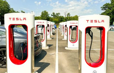 Leigh Delamere, Chippenham, Wiltshire, İngiltere - 25 Haziran 2023: Tesla arabası Swindon yakınlarındaki M4 otoyol benzin istasyonundaki Tesla elektrikli araç şarj istasyonlarından birinden şarj ediliyor.