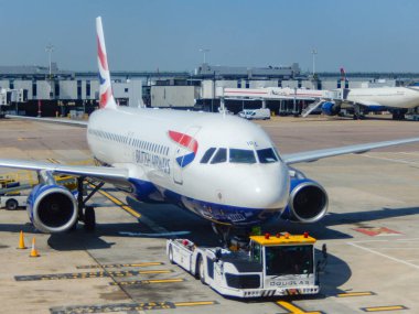 Londra, İngiltere, İngiltere - 14 Haziran 2023: British Airways Airbus A320 Jet (ruhsat G-MIDX) Heathrow Havaalanı 'nın ön tarafında römorkörle bağlanmış bir uçak..