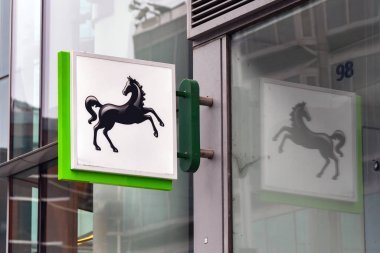 London, England, UK - 28 June 2023: Sign above the entrance of a branch of Lloyds bank in central London, with reflection in glass. clipart