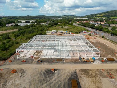 Pontyclun, Galler, İngiltere - 19 Temmuz 2023: Sainsbury 'nin mağaza zinciri için yapım aşamasındaki yeni bir süpermarketin çelik çerçevesinin havadan görünüşü