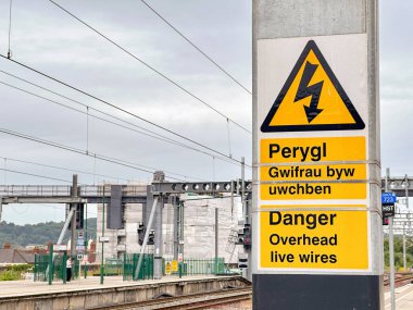 Cardiff, Wales - 27 Haziran 2023: Cardiff merkez tren istasyonundaki platformlardan birinde üstten elektrik kabloları uyarısı.