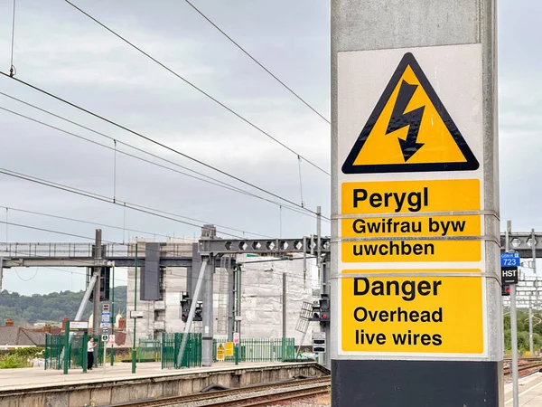 stock image Cardiff, Wales - 27 June 2023: Bilingual sign on one of the platforms at Cardiff central railway station warning of overhead electric wires.