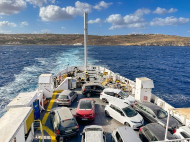 Gozo, Malta - 5 Ağustos 2023: Gozo adasıyla ana ada arasında giden bir feribotun güvertesindeki arabalar. Feribot Gozo Channel Line tarafından işletilmektedir..