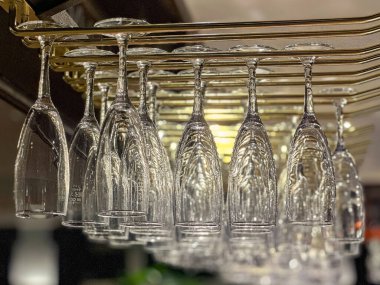 Şampanya kadehleri barın üstündeki askıda baş aşağı asılı duruyor.