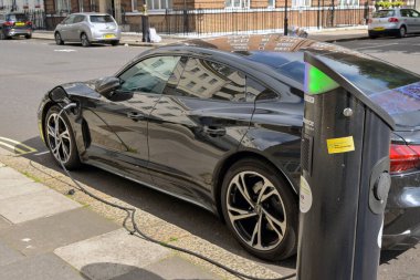Londra, İngiltere, İngiltere - 22 Ağustos 2023: Londra şehir merkezindeki bir caddede hızlı akü şarj noktasına elektrikli araba takıldı