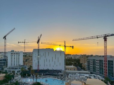St Julians, Malta - 4 Ağustos 2023: Günbatımında St Julians 'ın Skyline' ı yeni otel gelişmeleri üzerinde çalışan vinçlerle