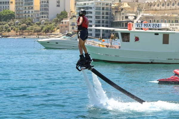 St Julians, Malta - 2 Ağustos 2023: St Julian Körfezi 'nde su püskürtme botları kullanmayı öğrenen genç kişi