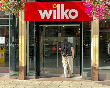 Cardiff, Wales - 15 Eylül 2023: Cardiff şehir merkezindeki Queen Caddesi 'ndeki Wilko mağazasının kilitli ön kapısından bakan kişi. Zincir iflas etti..