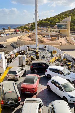 Gozo, Malta - 5 Ağustos 2023: Gozo adasının ana limanındaki bir feribotun güvertesine park edilmiş arabalar