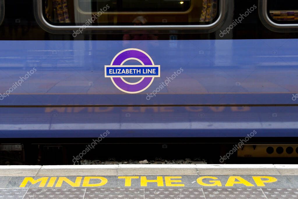 London, England, UK - 27 June 2023: Close up view of the side of a train on the new Elizabeth Line at London Paddington railway station and a Mind the Gap warning sign on the edge of the platform