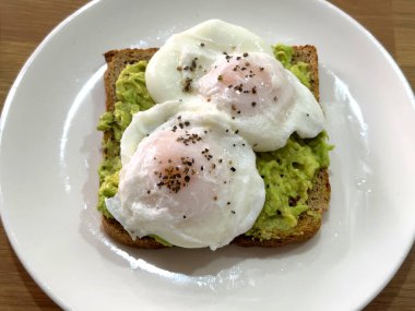 Kahverengi tost üzerine karabiberli iki haşlanmış yumurtayı yakından izleyin. Kimse yok..