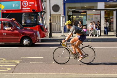 Londra, İngiltere, İngiltere - 22 Ağustos 2023: Londra şehir merkezinde Oxford caddesi boyunca bisiklet süren bisikletçi.