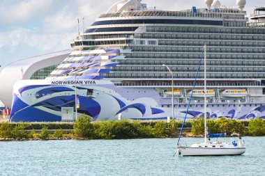 Miami, Florida, ABD - 5 Aralık 2023: Norveç Viva yolcu gemisi ön planda küçük bir yelkenliyle Maimi limanına yanaştı
