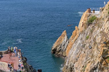 Acapulco, Meksika - 17 Ocak 2024: Turistler ünlü uçurum dalgıçlarının La Quebrada 'da denize dalmalarını izliyorlar