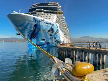 Manzallio, Mexicivo - 16 Ocak 2024: Norveç Bliss yolcu gemisi ve Manzanillo limanındaki arka plandaki yolcularla demirleme noktası ve halatları