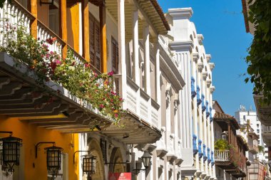 Cartagena, Kolombiya - 24 Ocak 2024: Tarihi eski Cartagena kasabasında balkonları olan dar binalar sokağı.