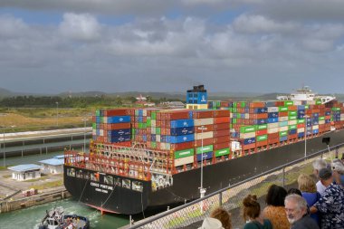 Kolon, Panama - 22 Ocak 2024: Panama Kanalı 'ndaki Agua Clara kilitlerinden geçmek için Costco Fortune adlı büyük bir konteynır gemisine yanaşan römorkör