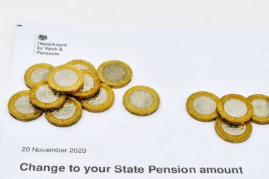 Cardiff, Galler - 1 Ocak 2024: Çalışma ve Emeklilik Dairesi 'nden Devlet Emeklilik maaşı değişikliğiyle ilgili resmi mektubun yanı sıra bir İngiliz sikkesi