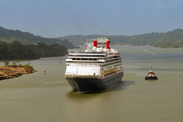 Panama Canal, Panama - 23 January 2024: Cruise ship Borealis sailing the Panama Canal escorted by a tug boat. The ship is operated by the Fred Olsen cruise line.