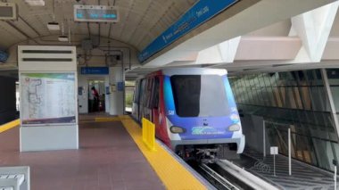 Miami, Florida, ABD - 5 Aralık 2023: Şehir merkezinde sürücüsüz Metromover hafif demiryolu taşımacılık sistemi ile bir istasyondan ayrılan tren
