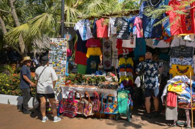 Puerto Quetzal, Guatemala - 19 January 2024: Cruise ship passenger browsing souvenirs on a market stall in the city's coastal port clipart