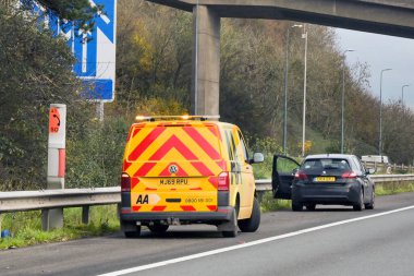Newport, Wales, UK - 29 November 2023: Breakkdown service van operated by the AA stopped to assist a motorist on the M4 motorway clipart