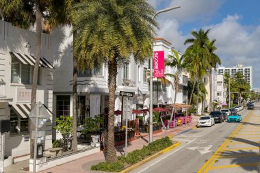 Miami, Florida, ABD - 1 Aralık 2023: Palmiye ağaçları ve şehrin güney sahil bölgesindeki bir sokakta bulunan sanat deco binaları