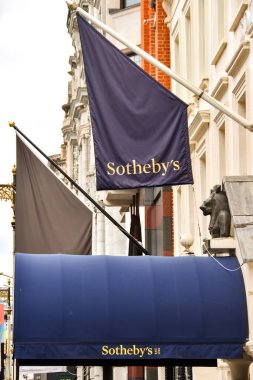 Londra, İngiltere, İngiltere - 27 Haziran 2023: Londra şehir merkezindeki New Bond Caddesi 'ndeki Sotheby' s Autcion House 'un girişinin üzerinde bayrak ve tepe örtüsü