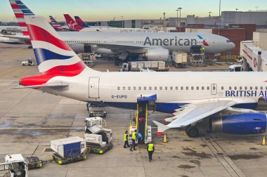 Londra, İngiltere, İngiltere - 29 Kasım 2023: Londra Heathrow havaalanında bir British Airways jetinden bavulları boşaltan havaalanı çalışanları.