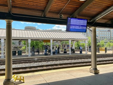 Alexandria, Washington DC, ABD - 1 Mayıs 2024: İnsanlar tren istasyonlarından birinde tren bekliyor.