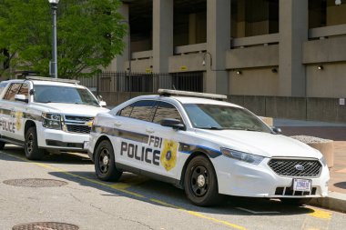 Washington DC, ABD - 30 Nisan 2024: Washington DC şehir merkezindeki J Edgar Hoover genel merkez binasının önünde FBI tarafından kullanılan polis devriye araçları