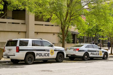 Washington DC, ABD - 30 Nisan 2024: Washington DC şehir merkezindeki J Edgar Hoover genel merkez binasının önünde FBI tarafından kullanılan polis aracı