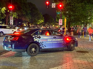 Washington DC, ABD - 30 Nisan 2024: Kiralık Araçlar Departmanı 'nın gece yarısı şehir merkezine yakın bir sokakta parlayan acil durum ışıkları olan devriye arabası