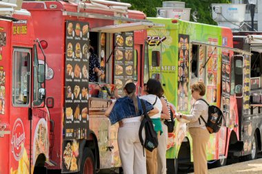 Washington DC, ABD - 3 Mayıs 2024: İnsanlar Washington DC 'nin ana yollarından birine park etmiş bir seyyar gıda kamyonundan fast food satın alıyorlar