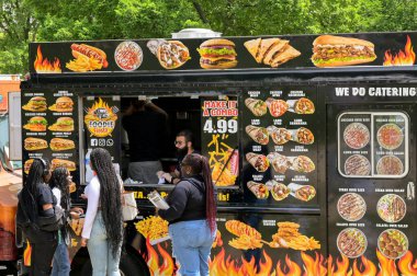 Washington DC, ABD - 3 Mayıs 2024: İnsanlar Washington DC 'nin ana yollarından birine park etmiş bir seyyar gıda kamyonundan fast food satın alıyorlar