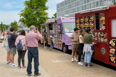 Washington DC, ABD - 3 Mayıs 2024: İnsanlar Washington DC 'nin ana yollarından birine park etmiş bir seyyar gıda kamyonundan fast food satın alıyorlar