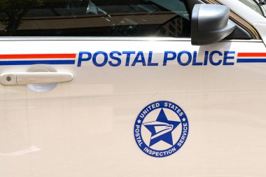 Washington DC, ABD - 30 Nisan 2024: ABD Posta Servisi Posta Polisi tarafından kullanılan devriye aracının yanında rozet