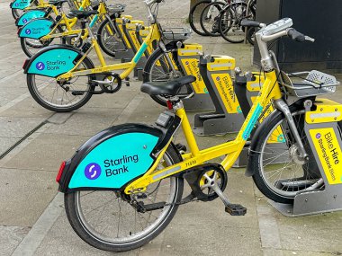 Manchester, İngiltere, İngiltere - 31 Mayıs 2024: Manchester şehir merkezindeki bir bisiklet paylaşım sisteminin park yerine park edilmiş bisiklet sırası