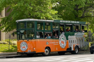 Washington DC, ABD - 30 Nisan 2024: Eski kasaba tramvayı Washington DC şehir merkezinde bir caddede turistik gezi otobüsünden atlıyor