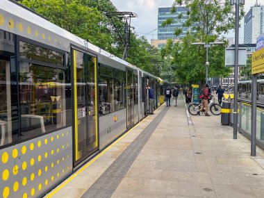 Manchester, İngiltere, İngiltere - 31 Mayıs 2024: Metrolink hafif demiryolu sistemindeki istasyonlardan birinde elektrik tramvayı