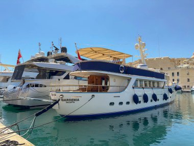 Valletta, Malta - 3 August 2023: The luxury yacht Gardenia mooored with other motor yachts in the marina in the Three Cities area of Valletta clipart