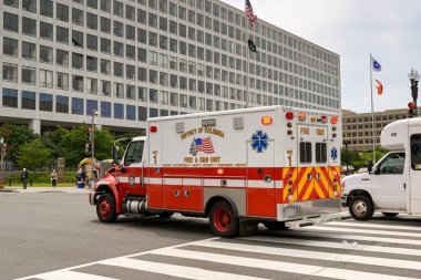 Washington DC, USA - 2 May 2024: Ambulance of the District of Columbia Fire and EMS Department with emergency lights flashing driving on a street in downtown Washington DC clipart
