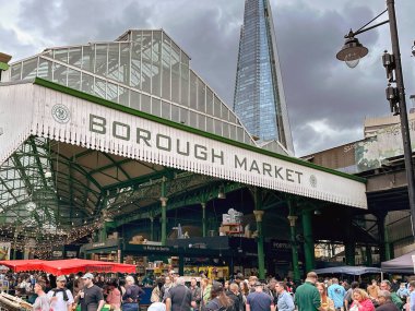 Londra, İngiltere, İngiltere - 3 Temmuz 2024: Londra şehir merkezindeki Borough Market 'in girişindeki insanlar. Arka planda Parça var..