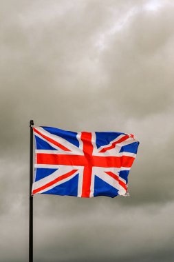 İngiliz bayrağı bulutlu bir bulutun altında güçlü bir rüzgarda dalgalanıyor. Kimse yok..